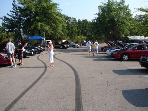 1992 Ford Taurus - Several cars are parked in a lot, with tire marks visible on the asphalt.