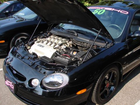 1992 Ford Taurus - A black 1996 Ford Taurus SHO is displayed with its hood open, the V8 engine and a commemorative sticker on the windshield.