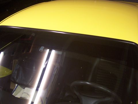 2002 Ford Mustang - Interior view of a yellow car, showing the dashboard and steering wheel.