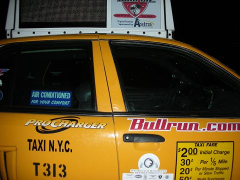 1992 Ford Crown Victoria - A yellow taxi cab displays 'TAXI N.Y.C.' and 'Bullrun.com' branding on its side.