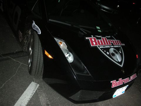 1992 Ford Crown Victoria - A black Lamborghini Gallardo is seen with Bullrun rally decals and a Hot Wheels sticker on the fender.
