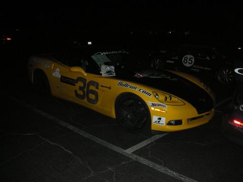 1992 Ford Crown Victoria - Yellow race car with racing decals parked at night, with another car visible in the background.