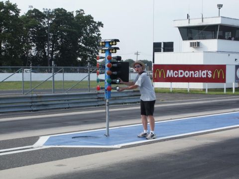 2001 Mercury Grand Marquis - A person adjusts a drag racing christmas tree at a track with a McDonald's sign visible in the background.
