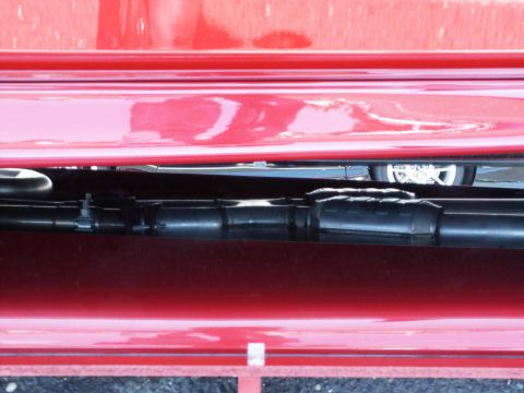 2001 Mercury Grand Marquis - Detail shot of an exhaust system and a wheel, with red bodywork visible.