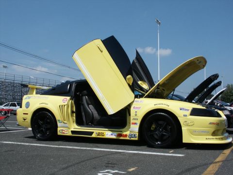 2001 Mercury Grand Marquis - Custom yellow sports car with doors and hood open at a car show.