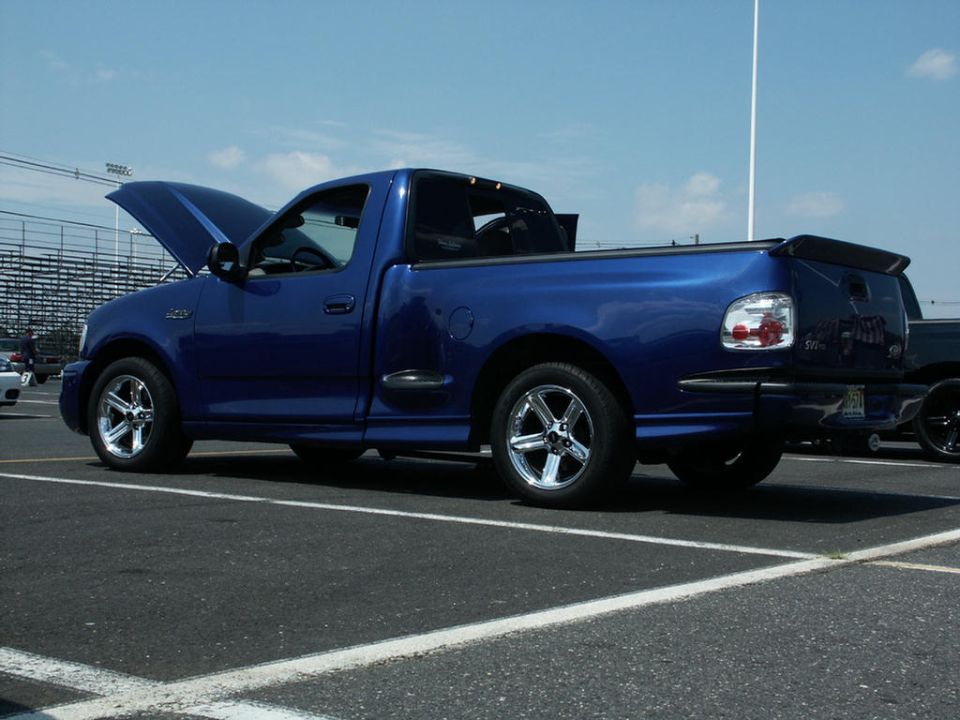blue Ford F-150 Lightning pickup truck with hood open, parked in lot