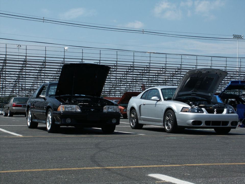 Silver 2001 Ford Mustang Cobra with hood open, parked next to a black car
