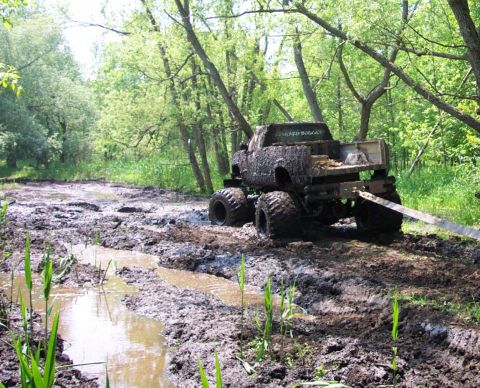 1978 Ford Bronco - Muddy off-road scene with a heavily soiled pickup truck stuck on a trail.