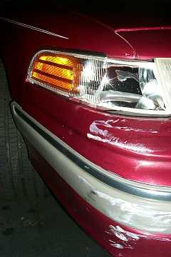 1992 Ford Crown Victoria - Front corner of a 1992 Ford Crown Victoria with visible damage to the bumper and headlight assembly.