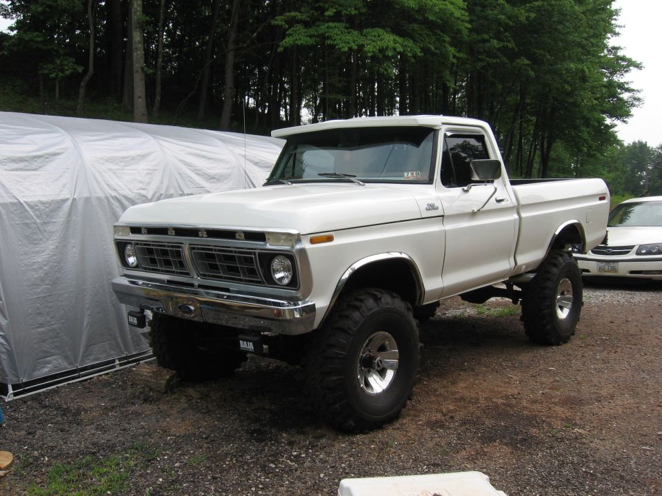 White lifted pickup truck with prominent grille and chrome accents