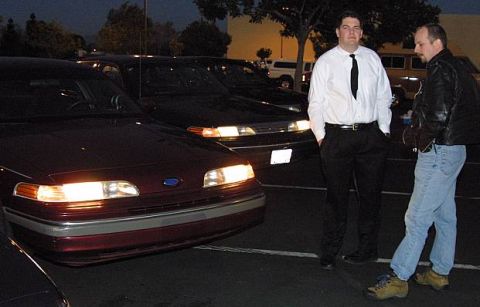 1992 Ford Crown Victoria - A red 1992 Ford Crown Victoria is parked at night, with its headlights illuminated.