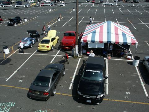 2001 Mercury Grand Marquis - A black Ford F-150 pickup truck is parked at an outdoor car show event, with a tent set up nearby.