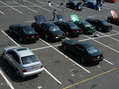 2001 Mercury Grand Marquis - A car show features multiple sedans parked in a lot with their hoods open.