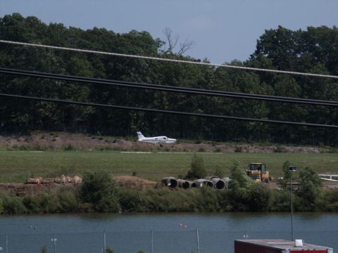 2001 Mercury Grand Marquis - An airplane is seen on a grassy field near a body of water, with a bulldozer visible in the distance.