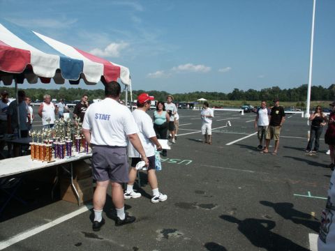 2001 Mercury Grand Marquis - Outdoor car show event with trophies displayed and staff members managing the area.
