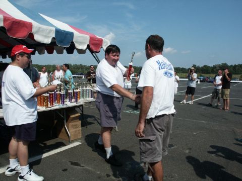 2001 Mercury Grand Marquis - Attendees receive trophies at the 4th Annual CJMF Car/Truck Show, an outdoor event with a large tent and many awards displayed.