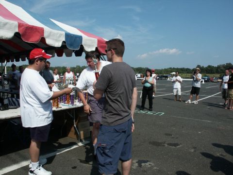 2001 Mercury Grand Marquis - Car show awards ceremony with people receiving trophies under a tent.