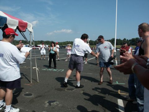 2001 Mercury Grand Marquis - An outdoor event with people interacting on a paved surface under a clear blue sky.