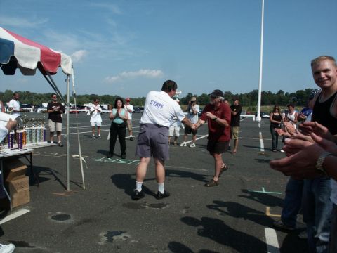 2001 Mercury Grand Marquis - Outdoor car show event with attendees and staff, trophies displayed under a tent.