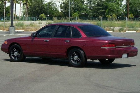 1992 Ford Crown Victoria - A maroon 1992 Ford Crown Victoria is shown from the rear passenger side in a parking lot.