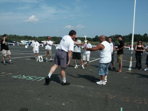 2001 Mercury Grand Marquis - Attendees at the 4th Annual CJMF Car/Truck Show receive a trophy, with other vehicles visible in the parking lot.
