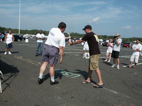 2001 Mercury Grand Marquis - A trophy is handed over at an outdoor car show event with spectators and vehicles present.