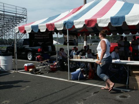 2001 Mercury Grand Marquis - A black Ford F-150 Lightning pickup truck is parked under a tent at a car show event.