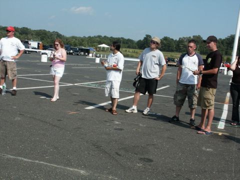 2001 Mercury Grand Marquis - People gather in a parking lot during an outdoor event with vehicles and tents visible.