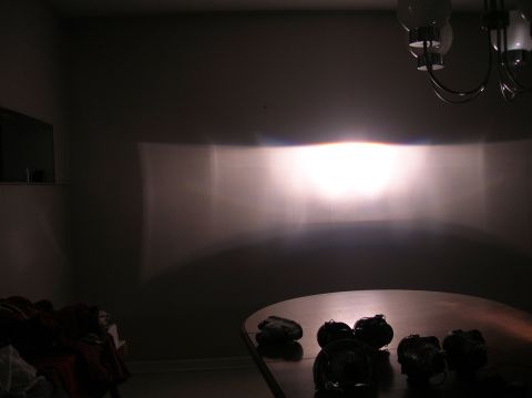 1996 Toyota 4Runner - A bright headlight beam pattern is projected onto a wall in a dimly lit room.