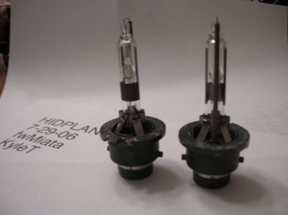 Two HID headlight bulbs on a paper with text HIDPLAN 7-29-06 fwMiata KyleT
