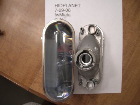 1996 Toyota 4Runner - Two parts of a car headlight assembly are shown, one clear lens and one metal housing.