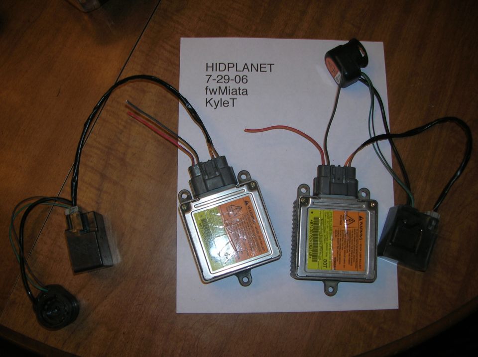 Two HID ballasts with wiring and a document with text