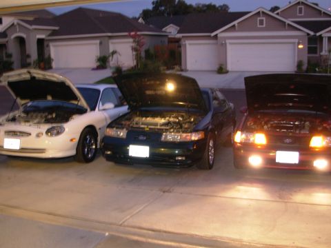 1995 Ford Taurus - front end shot of the group. 98 white, 95 green , and a 90 red.