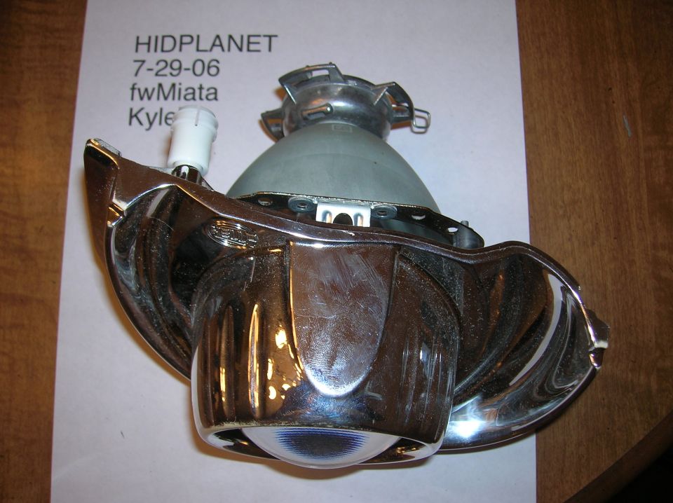 Headlight projector assembly with chrome housing and a white connector