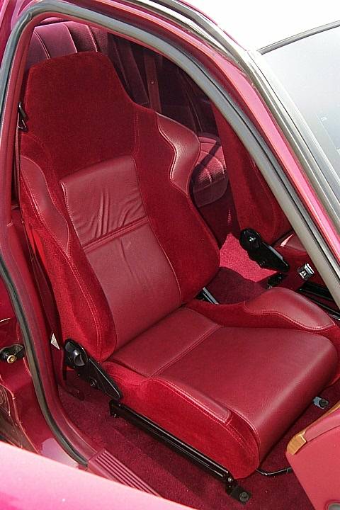 1992 Ford Crown Victoria - Interior shot of a burgundy/red sport bucket seat with matching leather and suede upholstery, viewed through the open door. The red carpeti…