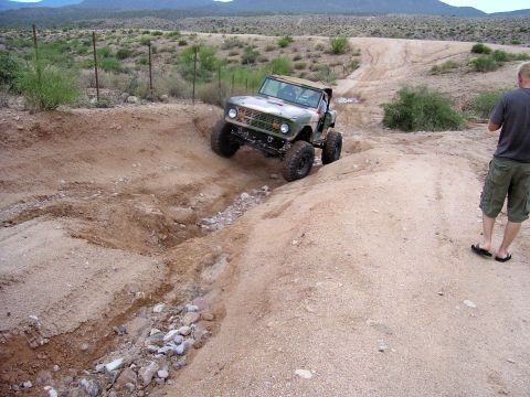 1991 Ford Bronco - A modified Ford Bronco navigates a challenging off-road course in a dry, arid landscape.