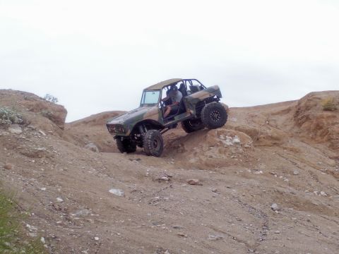 1991 Ford Bronco - This heavily modified off-road vehicle navigates a challenging rocky incline.