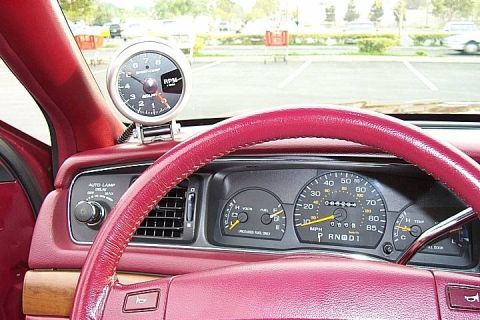 1992 Ford Crown Victoria - Interior view of a red/burgundy dashboard and instrument cluster, showing the speedometer, fuel and temp gauges, and an automatic PRNDL ind…
