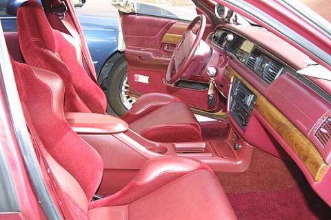 1992 Ford Crown Victoria - Customized car interior featuring red leather bucket seats, burgundy carpet, woodgrain dash trim and a chrome floor shifter.