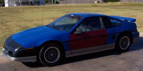 1988 Pontiac Fiero - This 1988 Pontiac Fiero features a two-tone paint scheme with blue on the front and rear, and maroon on the doors.