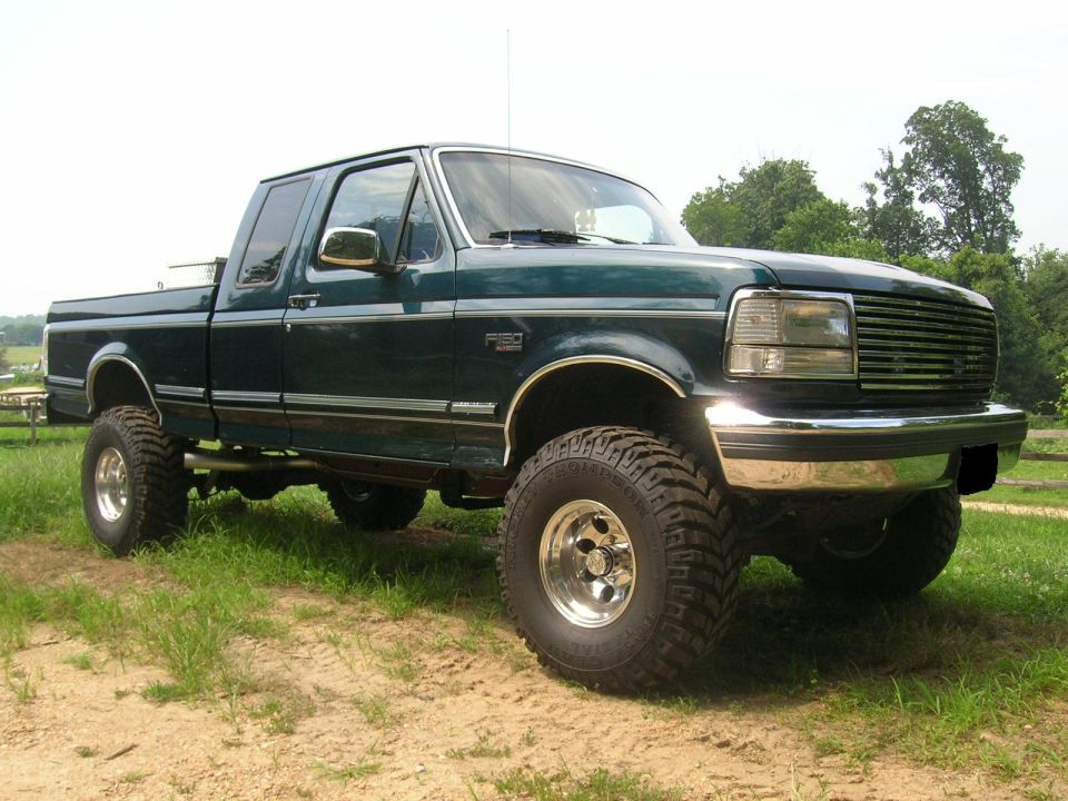 Dark green 1994 Ford F-150 pickup truck, lifted, 3/4 front view
