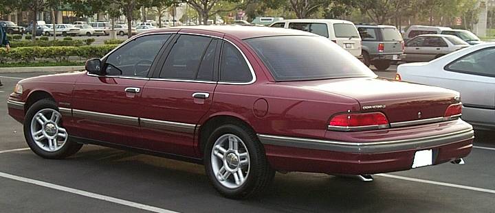 Maroon Ford Crown Victoria sedan, rear left three-quarter view in a parking lot