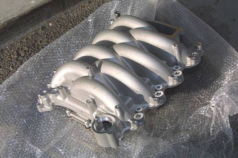 1992 Ford Crown Victoria - New bare cast-aluminum Ford modular V8 intake manifold with eight interleaved curved runners and a front throttle opening, resting on bubbl…