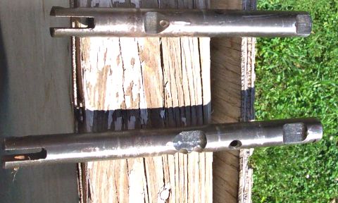 1978 Ford Bronco - Two metal shafts, possibly for a transfer case, are shown with visible slots and holes. One shaft has a stamped number '9'.