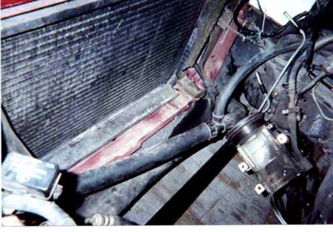 1992 Ford Crown Victoria - Looking down into a stripped engine bay from the driver's side with the engine removed: the radiator and condenser core stand at left, a re…