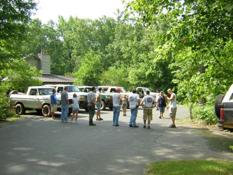 1979 Ford Bronco - Several vintage Ford trucks and SUVs are gathered outdoors with a group of people.