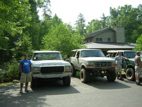 1979 Ford Bronco - Three Broncos and a truck are parked in front of a house on a sunny day.