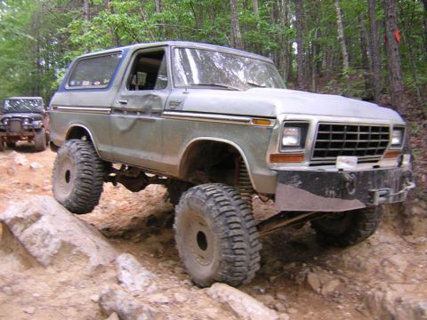 1979 Ford Bronco - A lifted 1978 Ford Bronco tackles a challenging off-road course with another vehicle visible in the background.