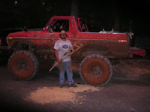 1979 Ford Bronco - A mud-covered red 1979 Ford Bronco is shown with a person holding crutches next to it.