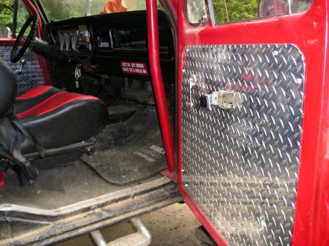 1996 Ford Bronco - Custom interior of an off-road vehicle with diamond plate accents and a roll cage.